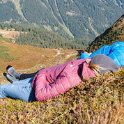 Zwei Personen sonnen sich in Merino Wandersocken auf einem Berg, ideal für Komfort und Temperaturregulierung bei Outdoor-Aktivitäten.