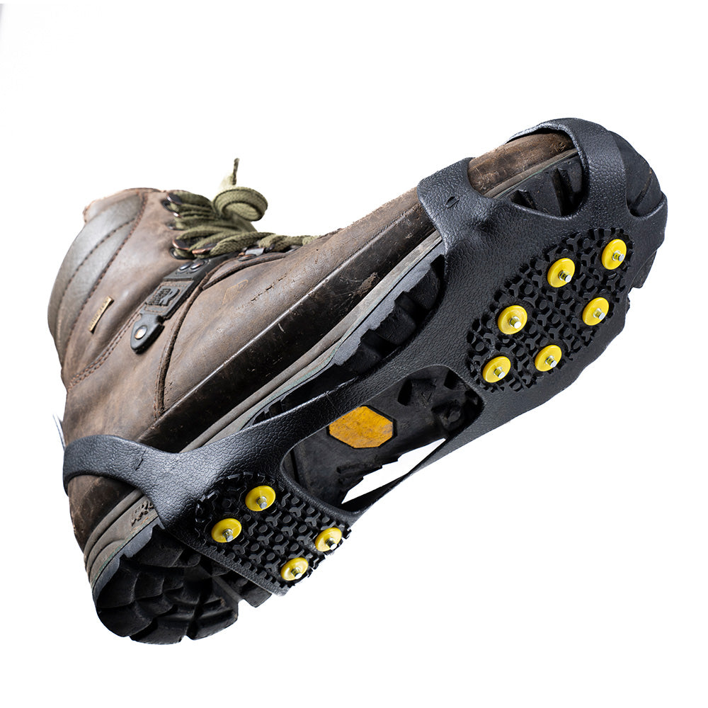 Ruggedes braunes Leder-Wanderstiefel mit schwarzen Alpin Loacker Easy Spikes, ausgestattet mit gelben Metallspikes für optimalen Wintergriff auf Eis und Schnee.