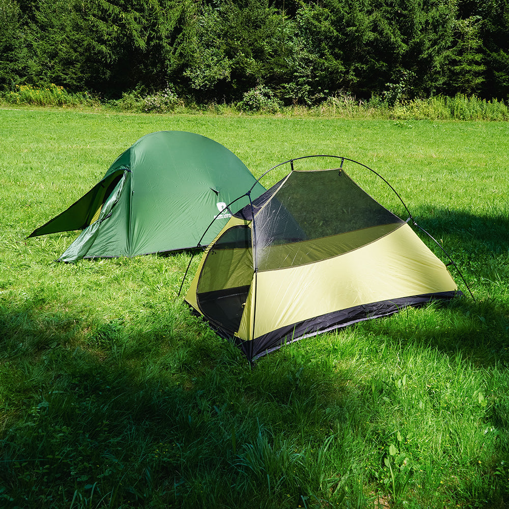 Cloud Pro Up 2 - 20D leichtes Zwei Mann Zelt in einem grasigen Waldlichtung, ideal für ultraleichte Abenteuer mit robustem, wetterfestem Design und einfacher Montage.