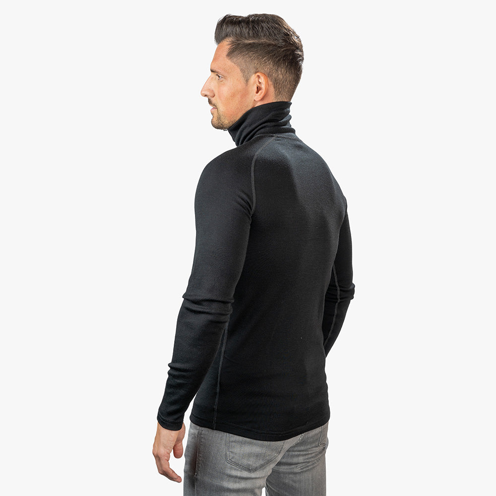 Mann trägt Merino Langarmshirt mit Zip Herren 230 g/m², ideal für Outdoor-Abenteuer, aus 100% Merinowolle, geruchshemmend und schnelltrocknend.