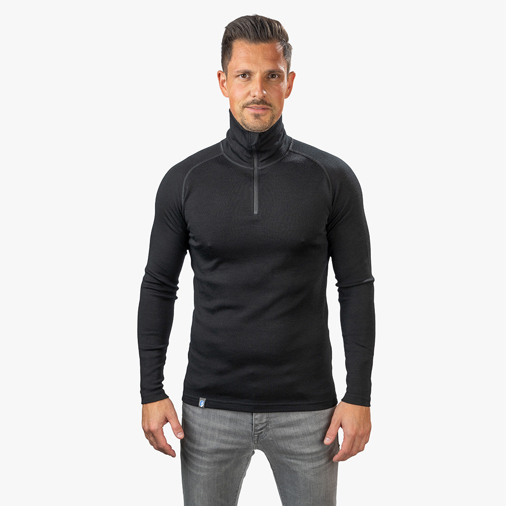 Modell trägt Merino Langarmshirt mit Zip Herren 230 g/m² aus 100% Merinowolle, ideal für Outdoor-Aktivitäten und Reisen, langlebig und komfortabel.
