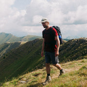 Hiker trägt Merino T-Shirt Herren 150 g/m², ideal für Outdoor-Aktivitäten, mit Corespun Merinowolle für Komfort und Strapazierfähigkeit, während er entlang eines Berggrats wandert.