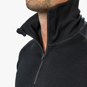 Person trägt ein Merino Langarmshirt mit Zip Herren 230 g/m², sichtbarer Reißverschluss und Kragen, ideal für Outdoor-Aktivitäten und Reisen.