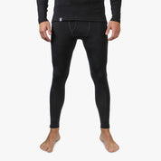 Person trägt schwarze Lange Merino Unterhose Herren 150 g/m2, ideal für Outdoor-Aktivitäten, dank CORESPUN-Technologie langlebig und komfortabel, aus Merinowolle und synthetischen Fasern gefertigt.