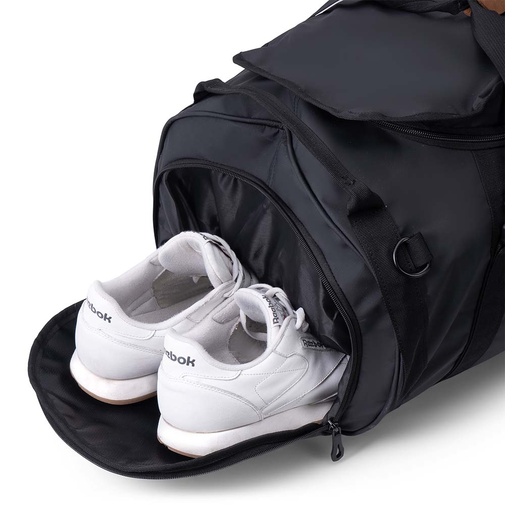 Schwarze Reisetasche, Sporttasche & Duffel Bag mit offenem Schuhfach, zeigt weiße Sneaker. Perfekt organisiert, wasserabweisend, ideal für Abenteuer und Reisen.