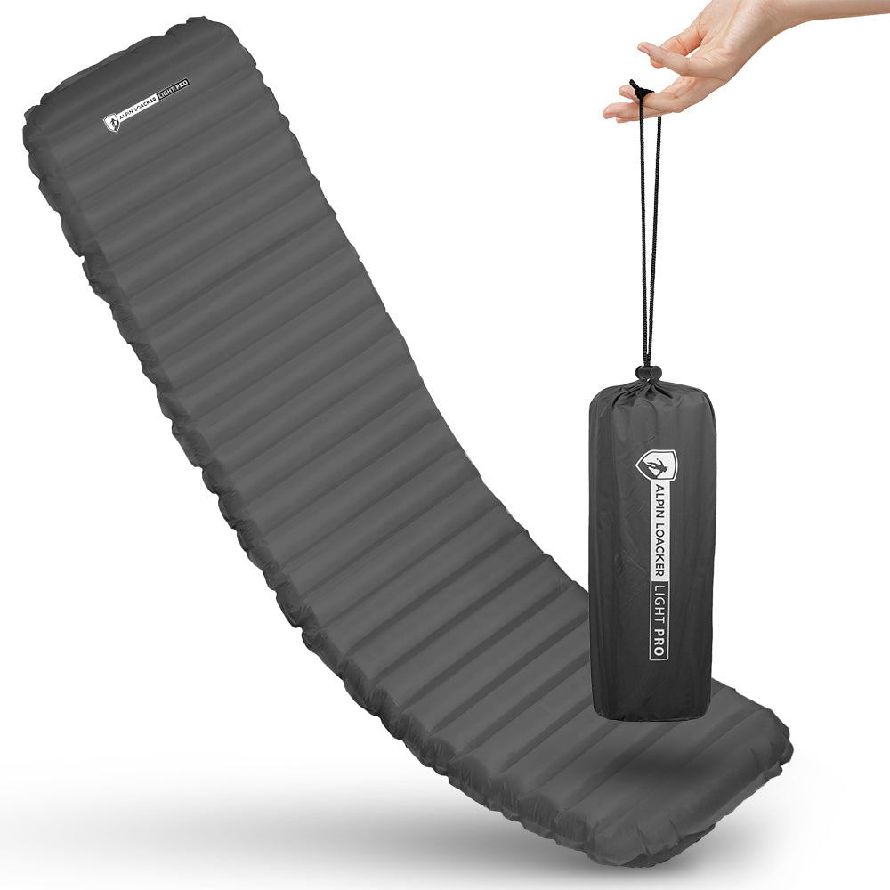 Leichte Isomatte isoliert mit Kunstdaune, aufgeblasen im Hintergrund, kompakt im Vordergrund im Packsack gehalten, ideal für Camping und Trekking.