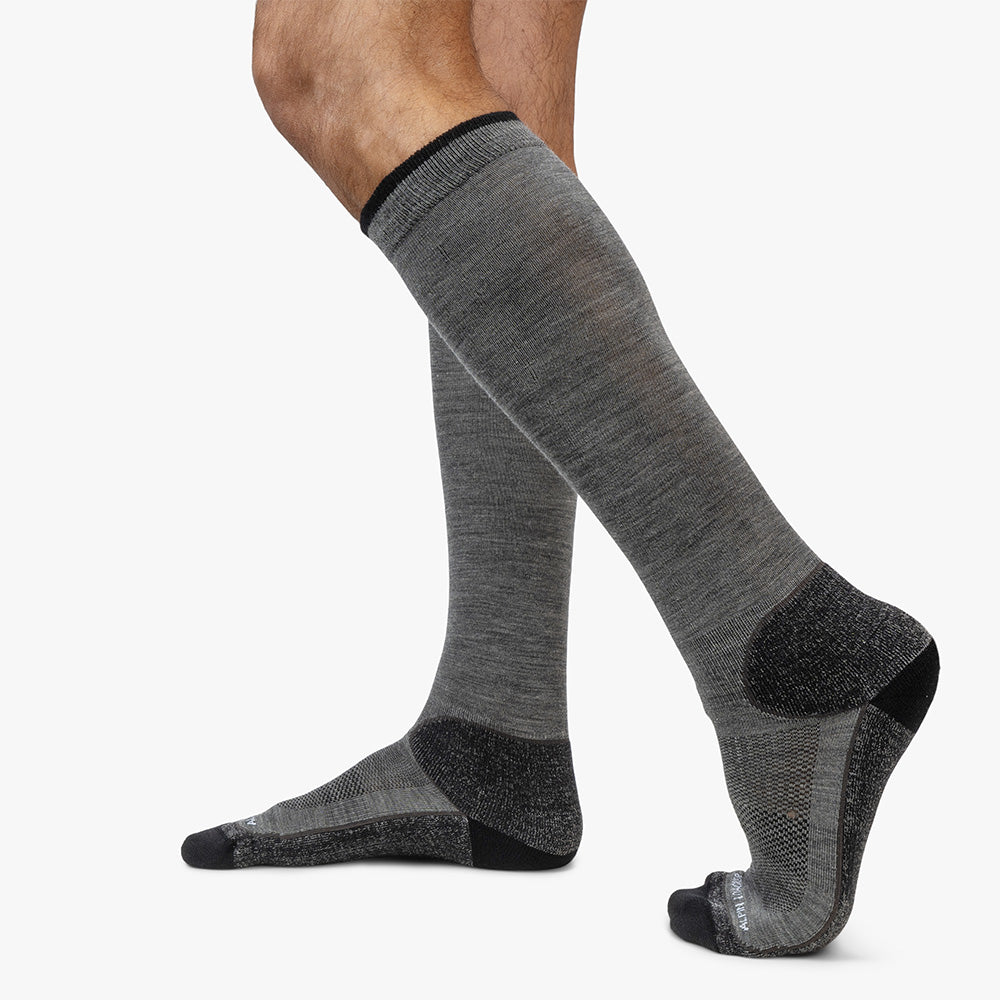Hohe Merino Ski Socken Herren & Damen: Heather-graue Skisocken aus Merinowolle mit verstärkter Ferse und Zehen, getragen an Beinen, ideal für komfortable Skitage.