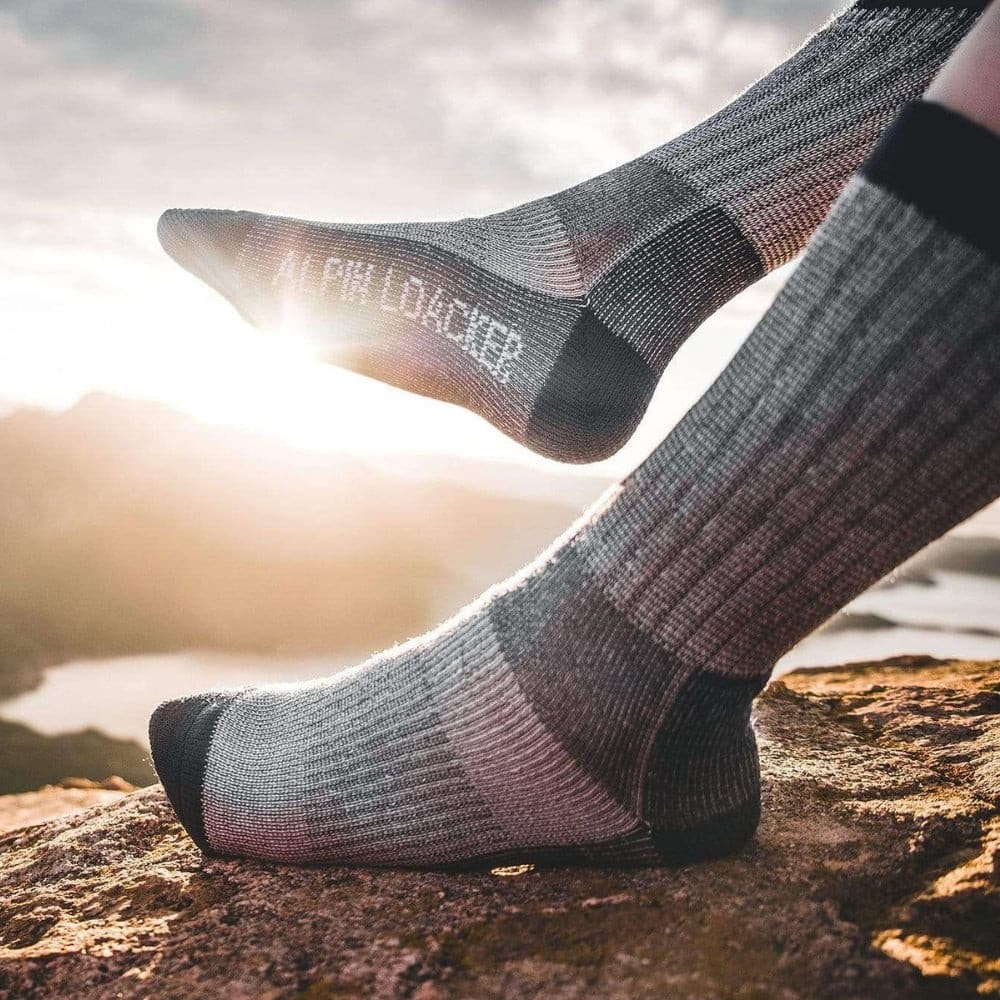 Merino Wandersocken Classic Herren & Damen auf Felsvorsprung, ideal für Outdoor-Abenteuer. Hochwertige Merinowolle sorgt für Komfort und Langlebigkeit.