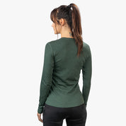 Rückansicht einer Frau im Merino Langarm Shirt Damen 230 g/m2, ideal für Outdoor-Aktivitäten, aus 100% Merinowolle, temperaturregulierend und geruchsneutral.