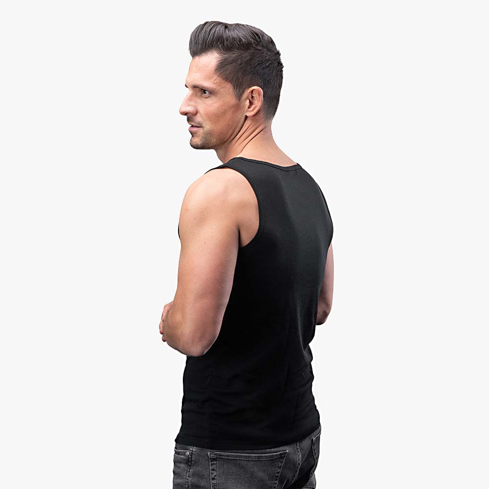 Mann im Merino Tank Top Herren 150 g/m2, ideal für Outdoor-Aktivitäten, aus CORESPUN Merinowolle für Komfort und Strapazierfähigkeit, stehend im Profil.