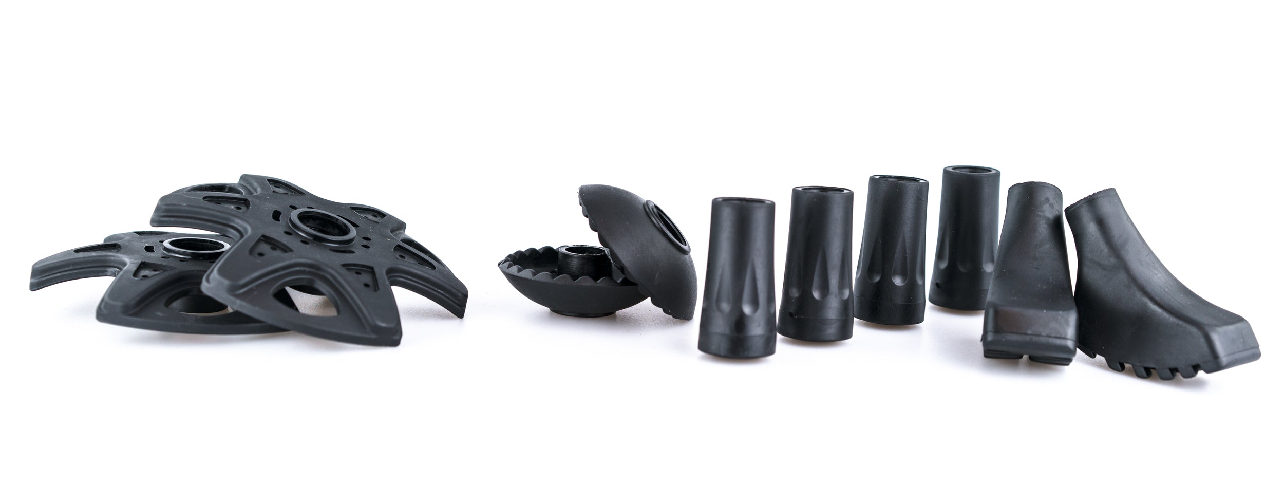 Ein Paar schwarze Gummistiefel und mehrere schwarze Objekte, möglicherweise Outdoor-Ausrüstung, eng beieinander auf einem weißen Hintergrund.