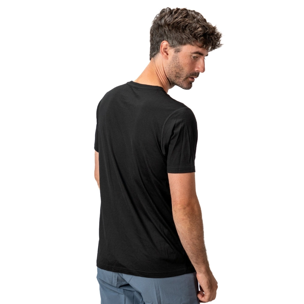 Männliches Modell in 100% Merino T-Shirt Herren 160 g/m² - ultrafein, seitlich stehend, zeigt Komfort und Funktionalität für Outdoor-Aktivitäten.