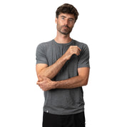 Mann trägt 100% Merino T-Shirt Herren 160 g/m² - ultrafein, perfekt für Outdoor-Aktivitäten. Kurze Ärmel, neutraler Gesichtsausdruck, ideal für Komfort und Leistung.