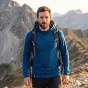 Mann auf Bergtour im blauen Merino Hoodie Herren 230 g/m² von Alpin Loacker