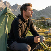 Schwarzer Merino Pullover mit Kapuze beim Camp in den Bergen
