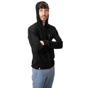 Mann trägt 100% Merino Sport Hoody Zip Herren - 230 g/m², schwarze Kapuzenjacke mit seitlicher Brusttasche, ideal für Outdoor-Aktivitäten.