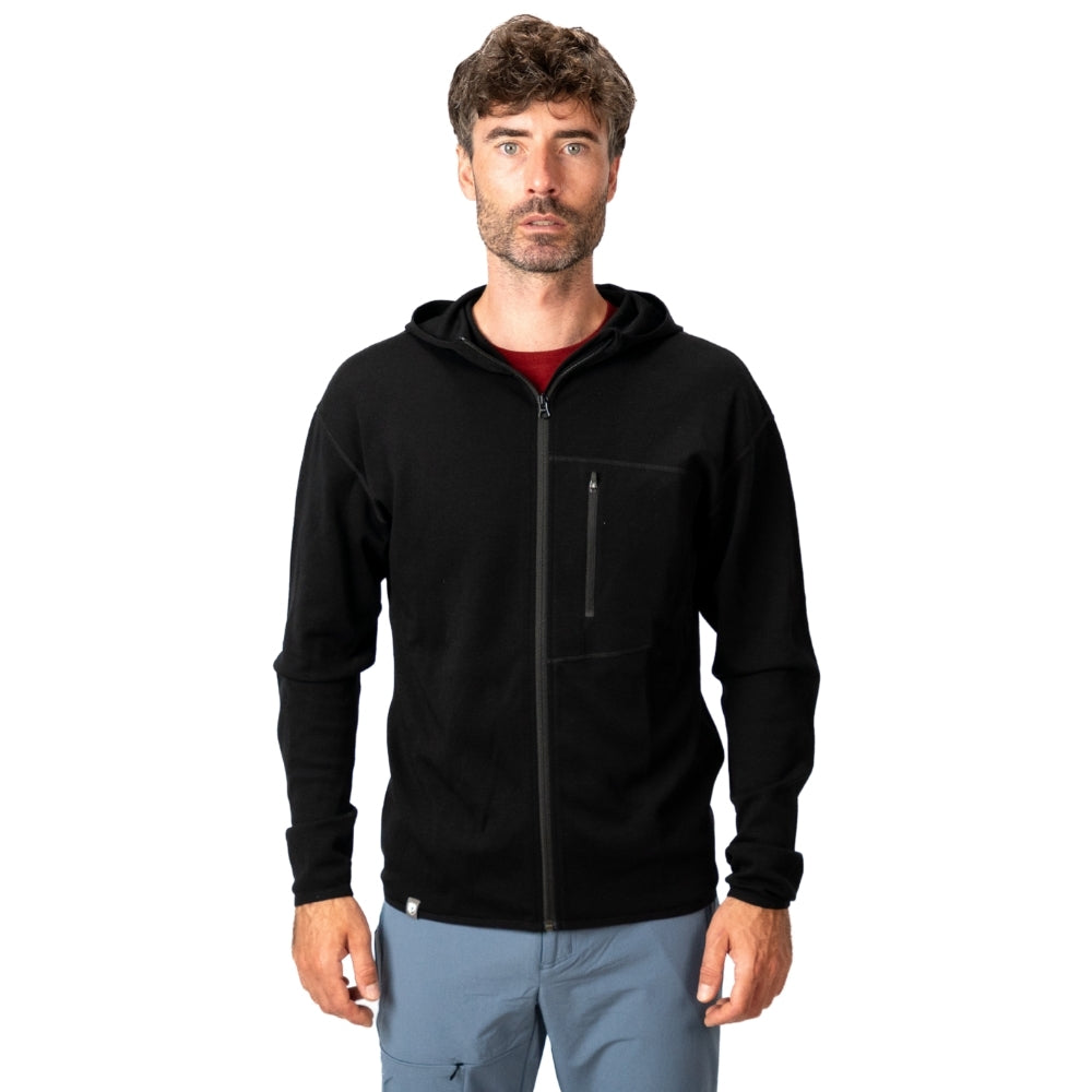 Mann in schwarzer 100% Merino Sport Hoody Zip Herren - 230 g/m2 mit Brusttasche, ideal für Outdoor-Aktivitäten, steht vor weißem Hintergrund.