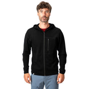 Mann in schwarzer 100% Merino Sport Hoody Zip Herren - 230 g/m2 mit Brusttasche, ideal für Outdoor-Aktivitäten, steht vor weißem Hintergrund.