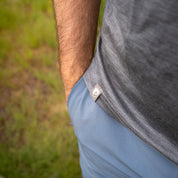 Nahaufnahme eines Arms in einer Tasche, zeigt das 100% Merino T-Shirt Herren 160 g/m² - ultrafein, ideal für Outdoor-Aktivitäten, mit weichem, temperaturregulierendem Stoff.