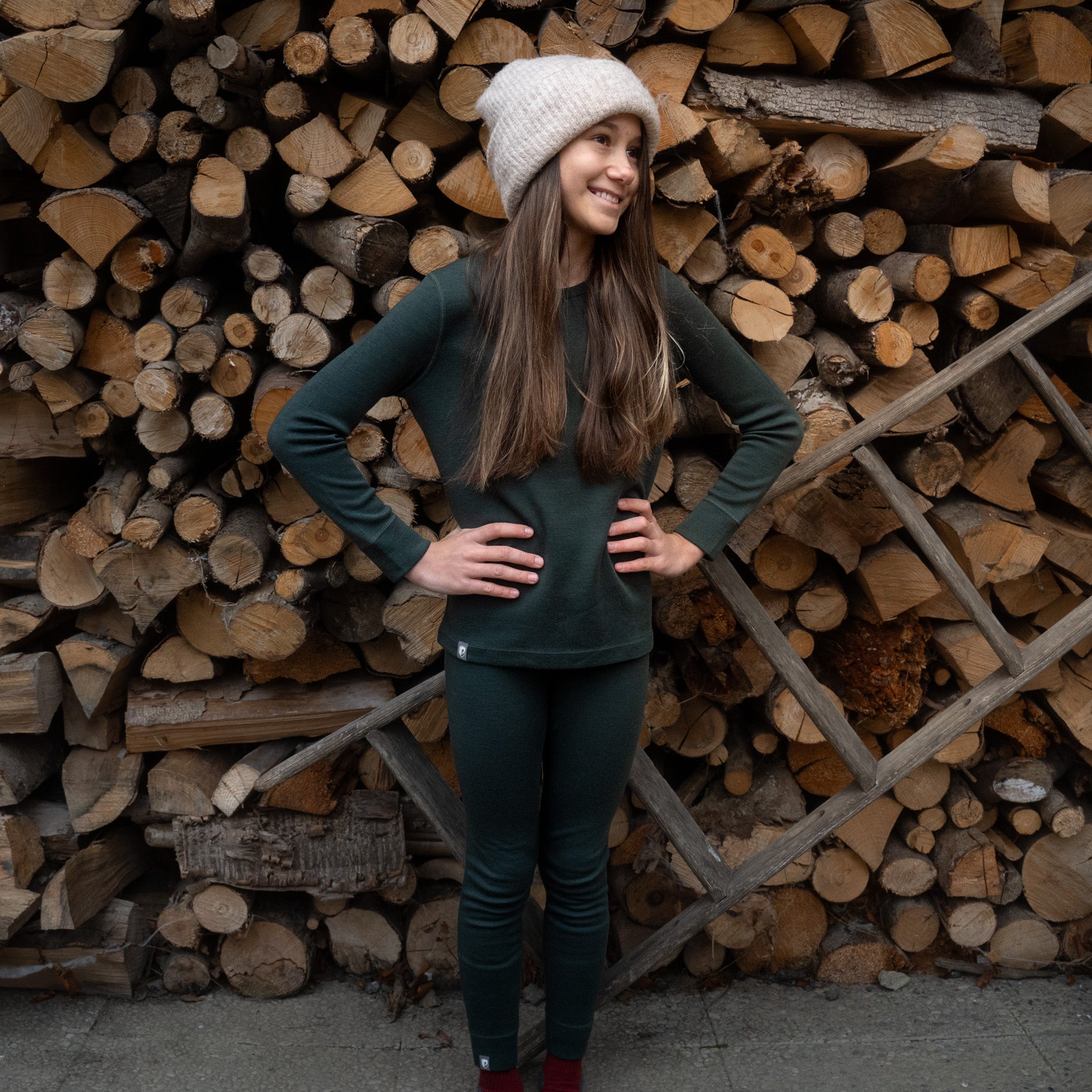 Mädchen trägt das Merino Set für Kinder in grün, aus 100% Merinowolle, perfekt für kühle Tage