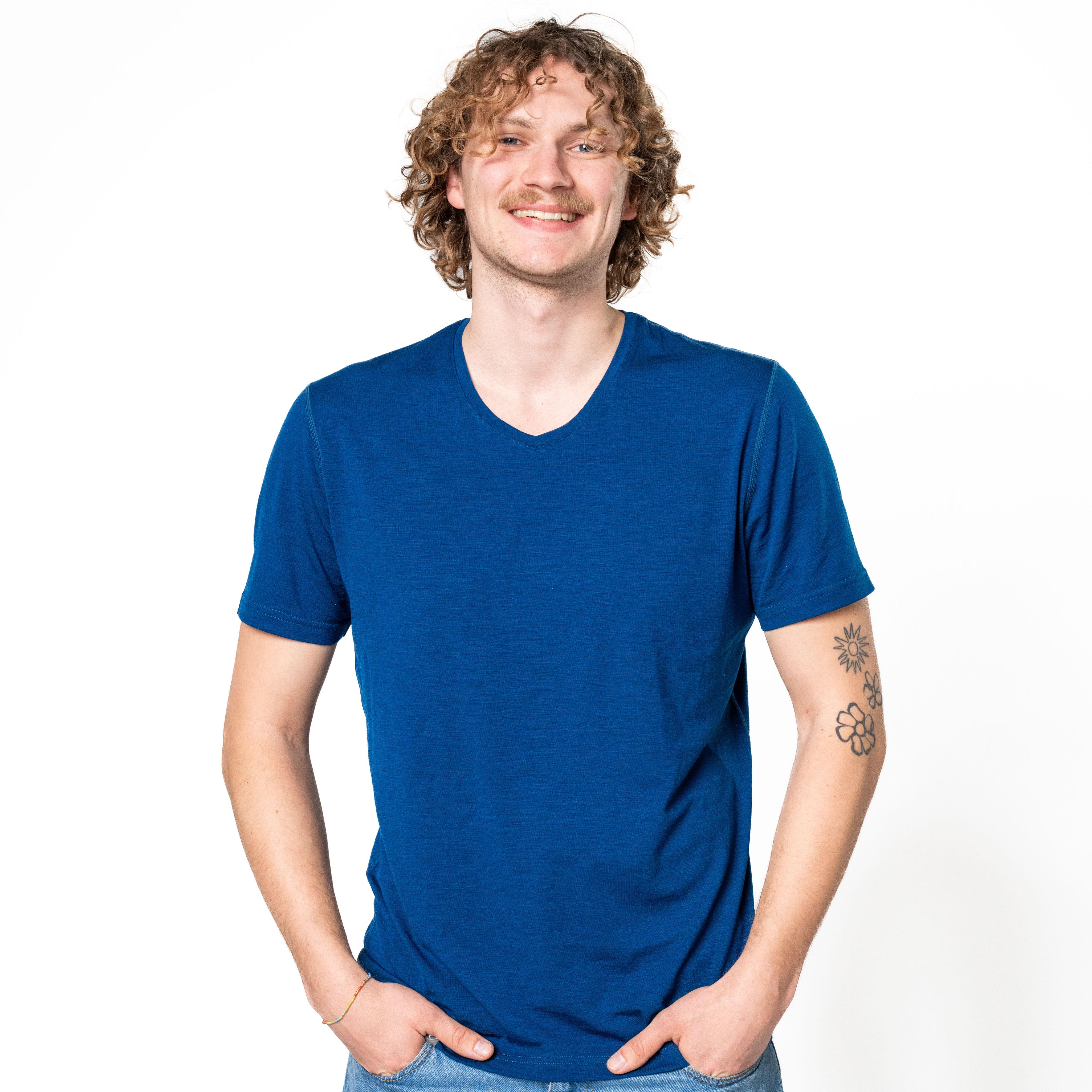 Männliches Model trägt Merino V-Neck T-Shirt Herren in blau, perfekt für Outdoor-Aktivitäten und Alltag, vor weißem Hintergrund