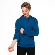 Model trägt blauen Alpin Loacker Merino Hoodie