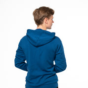 Model trägt blauen Alpin Loacker Merino Hoodie