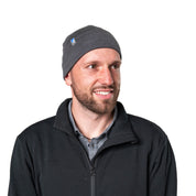 Model trägt eine Merino Mütze Herren & Damen 230g/m², schwarzer Strick, aus 100% Merinowolle, ideal für Outdoor-Aktivitäten, leicht und komfortabel