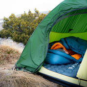 Frau liegt im Zelt bei frostigen Temperaturen auf der R8 Winterisomatte von Alpin Loacker, die einen optimalen Isolationsschutz bei niedrigen Temperaturen bietet