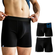Coolmax Merino Boxershorts Herren – 2er Set, schwarze Boxer-Shorts mit mittlerer Länge und unterstützendem Beutel, präsentiert auf einem Modell, daneben zwei identische Paare.