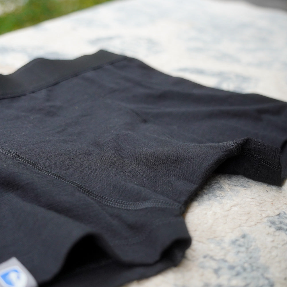 Nahaufnahme einer schwarzen DamenMerino Shorts, auf der die Nähte gut zu sehen sind.