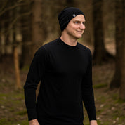 Mann in schwarzem Merino Langarm Shirt Herren 150 g/m², perfekt für Outdoor-Aktivitäten, mit innovativer CORESPUN-Technologie für Komfort und Funktionalität.