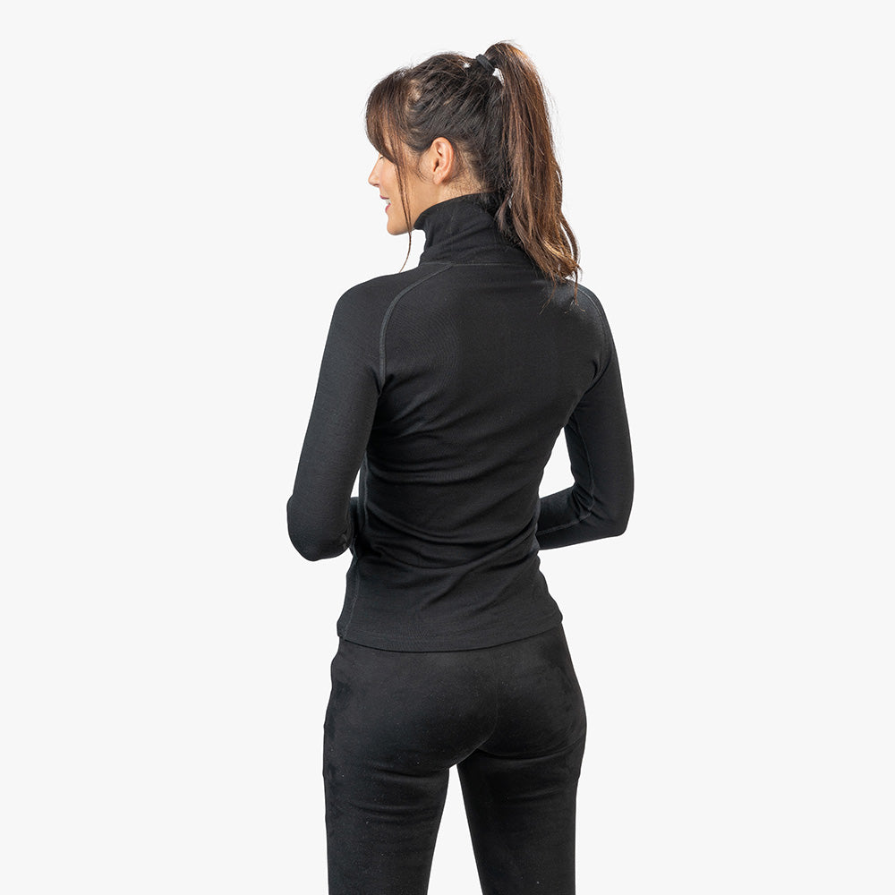 Frau trägt Merino Langarmshirt mit Zip Damen 230g/m², ideal für Outdoor-Abenteuer, aus atmungsaktiver, geruchsresistenter Merinowolle, perfekt für Wanderungen und Reisen.