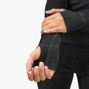 Person trägt ein Merino Langarmshirt mit Zip Damen 230g/m2, kombiniert Atmungsaktivität und Geruchsresistenz, ideal für Outdoor-Aktivitäten. Sichtbar ist ein schwarzes Handgelenkband.