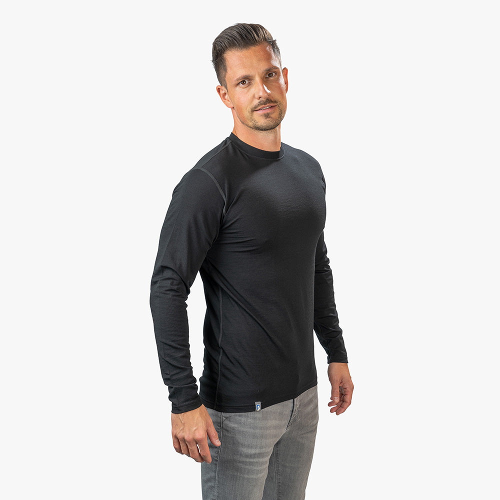 Mann trägt Merino Langarm Shirt Herren 150 g/m², ideal für Outdoor-Aktivitäten. Kombiniert Komfort mit innovativer CORESPUN-Technologie. Perfekt für Wandern und Alltagsgebrauch.