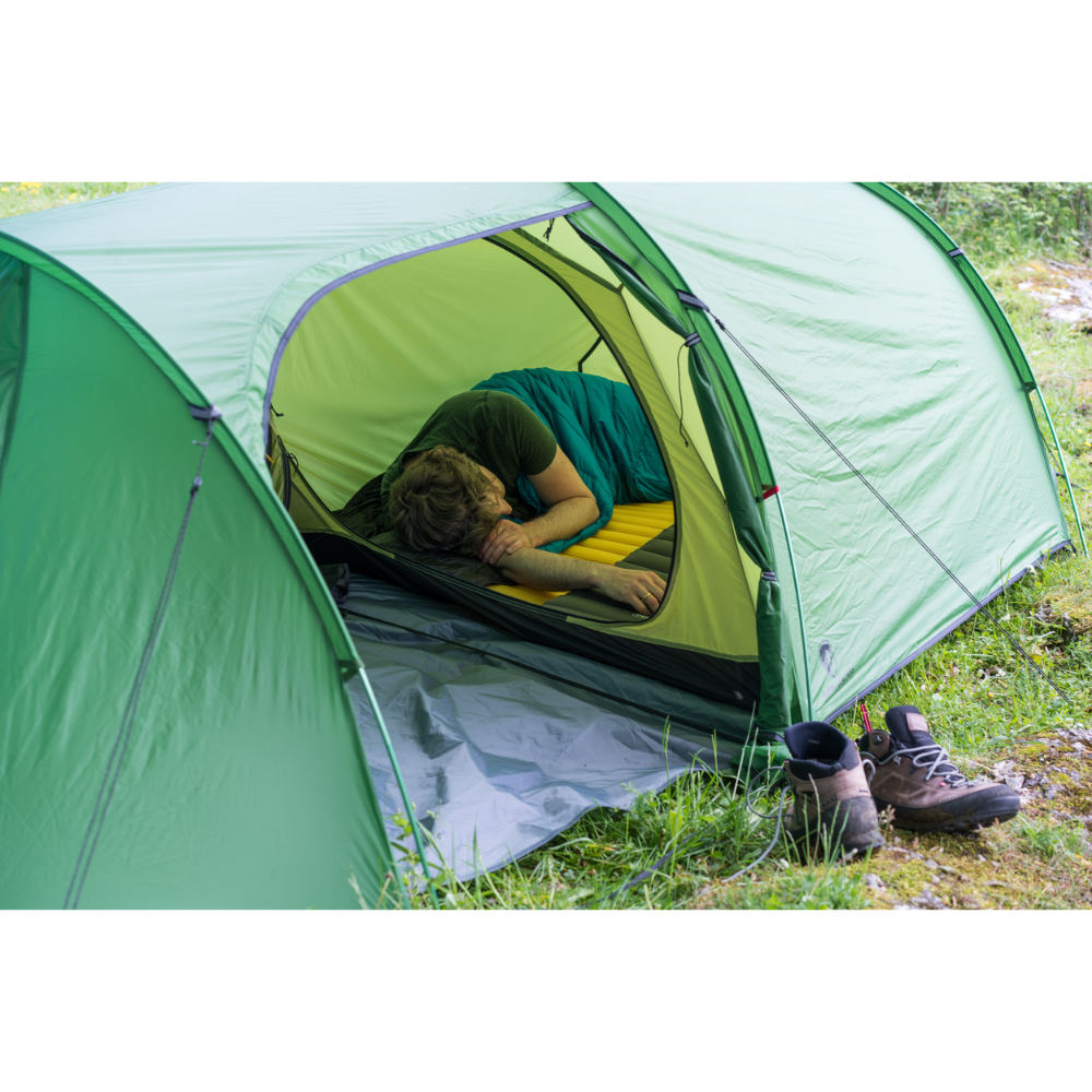 Tunnelzelt für 2 Personen 1.99kg in einem Camping-Setup, Person schläft im Zelt, Schuhe draußen auf Gras, ideal für Outdoor-Abenteuer.