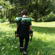 Tunnelzelt für 2 Personen 1.99kg: Eine Person mit großem Rucksack in einem Feld, ideal für Outdoor-Abenteuer und leichtes Gepäck. Perfekt für Wanderer.