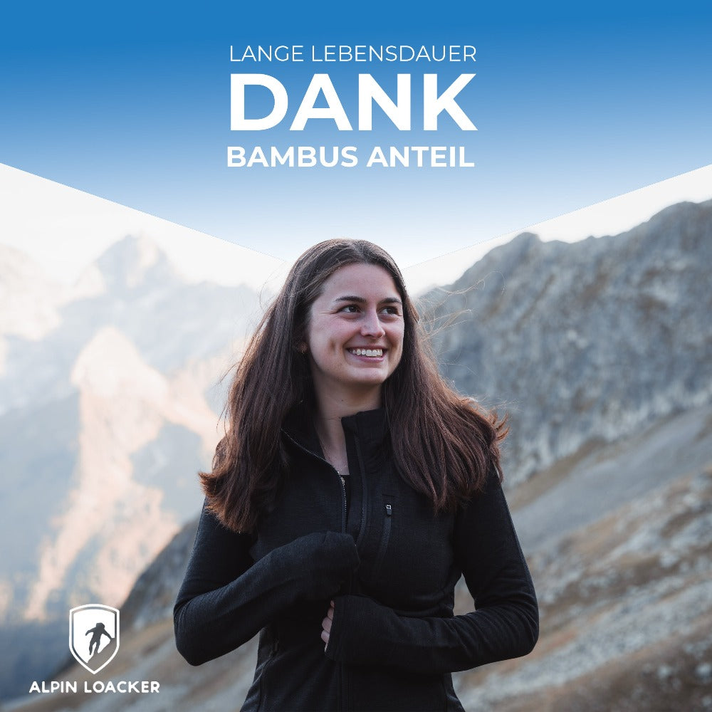 Frau lächelt vor Bergkulisse, trägt Merino Jacke Damen 270 g/m², perfekt für Outdoor-Abenteuer und Alltag, bietet Komfort und Funktionalität.
