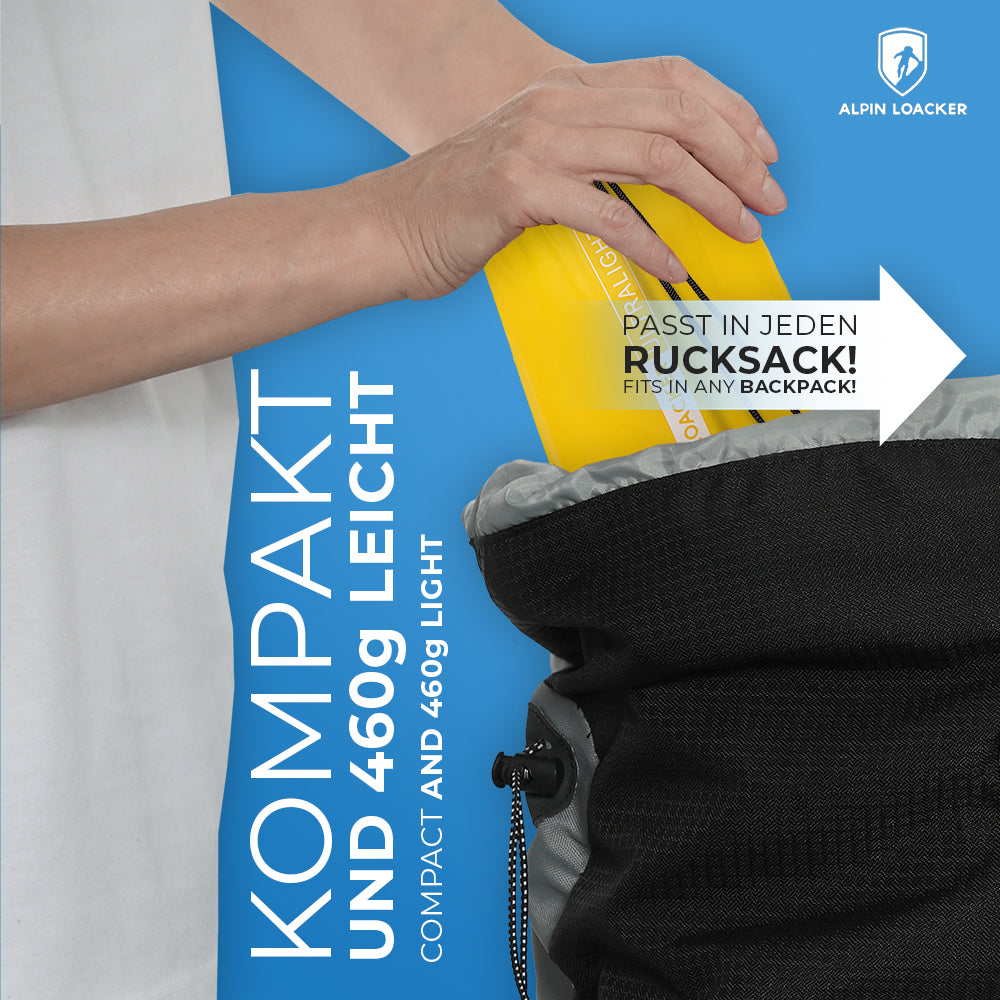 Person legt gelbe Tasche in schwarze Tasche, zeigt die Ultraleichte Isomatte isoliert mit Kunstdaune - 460g, ideal für Outdoor-Abenteuer und minimalen Platzbedarf.