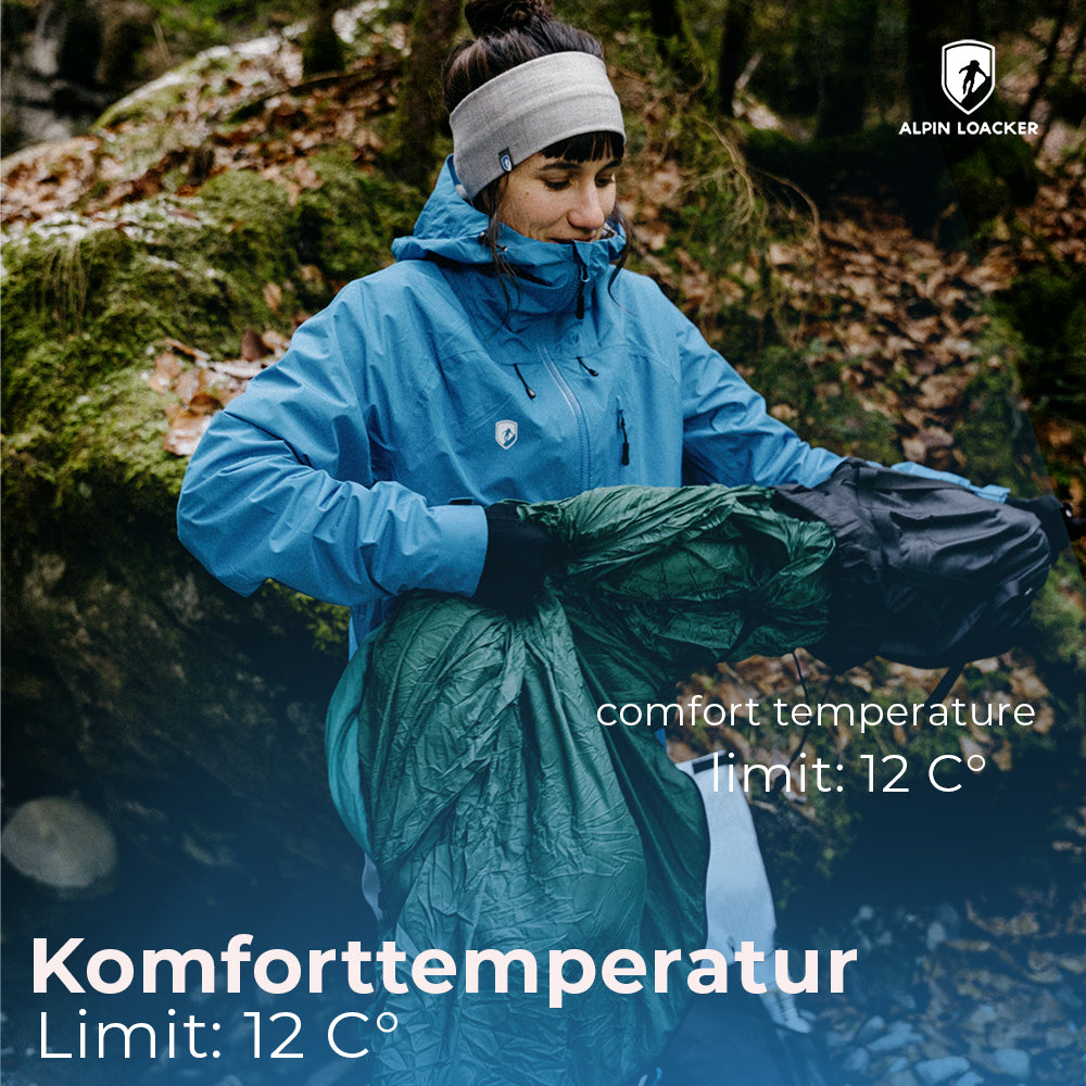 Frau in blauer Jacke mit SYN PRO - Synthetik Sommer Schlafsack ultraleicht für Outdoor-Abenteuer, ideal für milde Nächte und nachhaltigen Komfort.