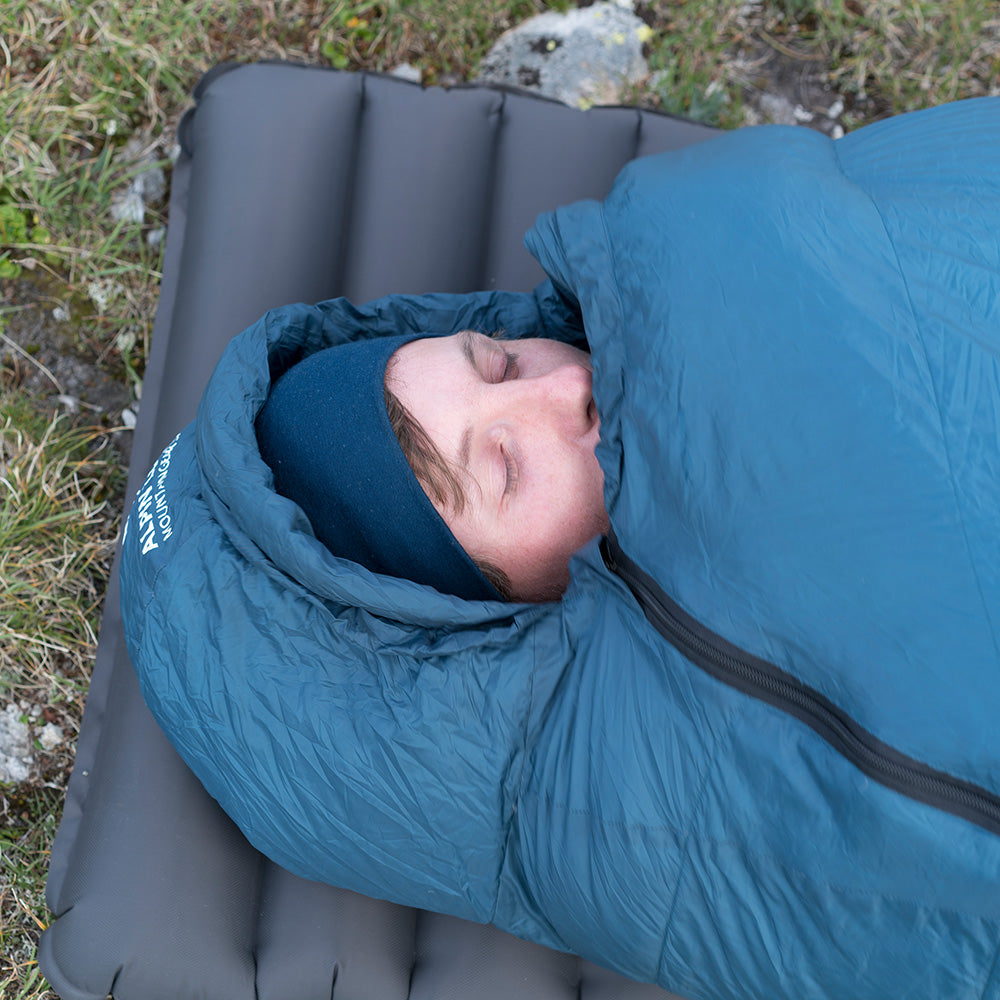 Mann schläft im Down Pro 3 Jahreszeiten Schlafsack 860g, ideal für Outdoor-Abenteuer bei kühlen Temperaturen, sichtbar im leichten und kompakten Design.